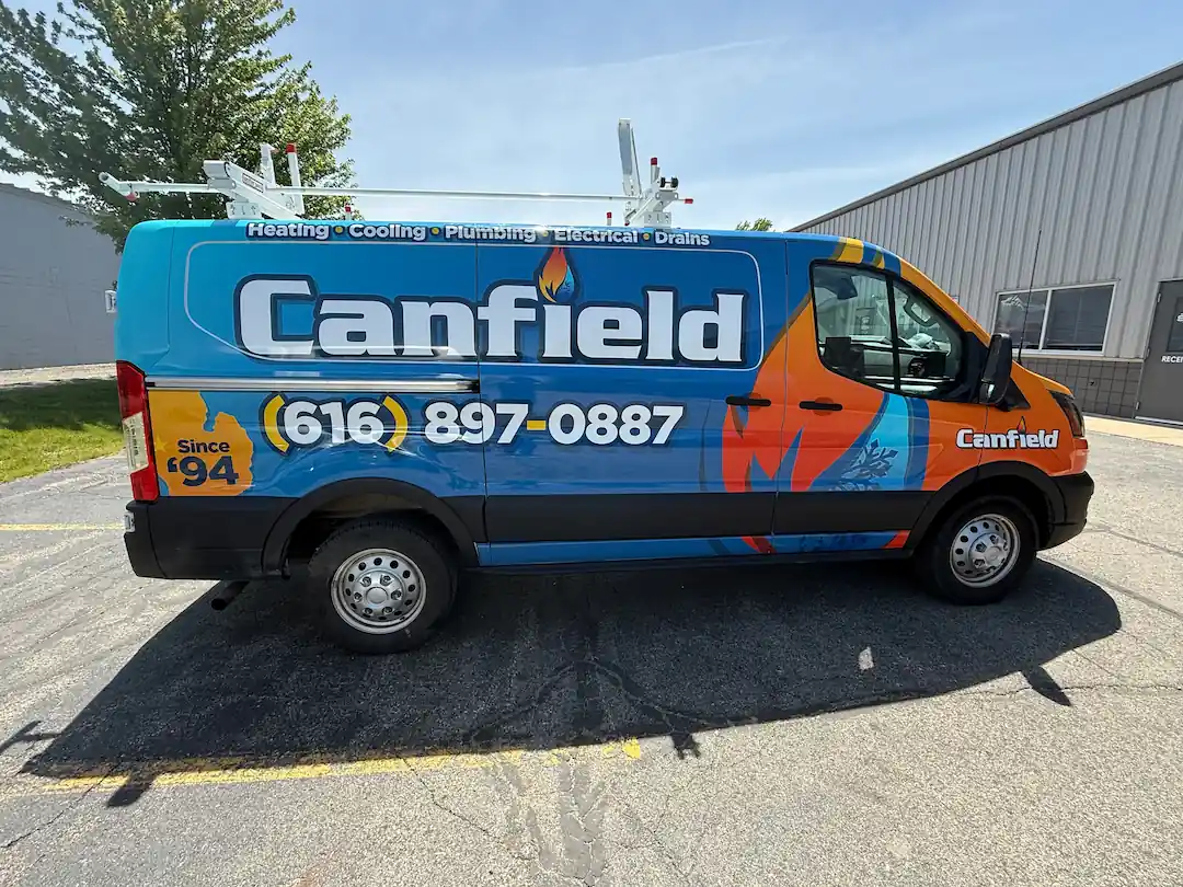 Canfield Heating, Cooling, Plumbing & Electrical service van in Lowell, MI with branded wrap and contact details